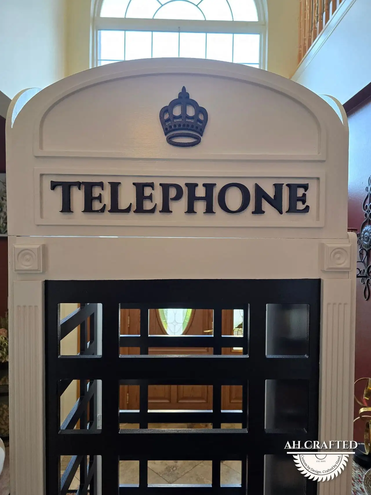 Close detail of the CNC-cut crown crest mounted above the TELEPHONE sign.