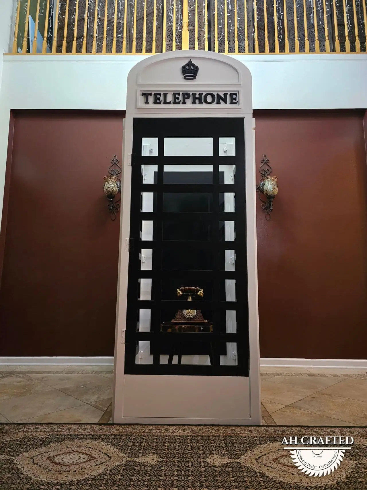 The finished telephone box lit at night, a vintage handset on the interior shelf.